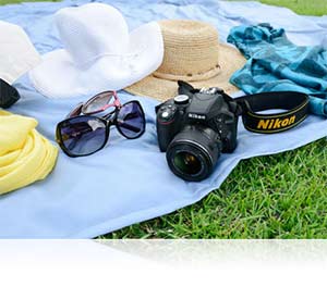 Photo of the Nikon D3300 and hats and sunglasses on a blanket on the grass showing lightweight design