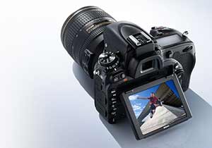 Photo of the D750 DSLR with NIKKOR lens and image of a parkour athlete on the LCD