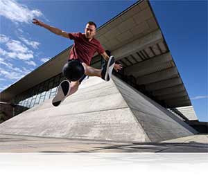 Nikon D750 photo of a male parkour athlete in mid air jump showing speed of the camera